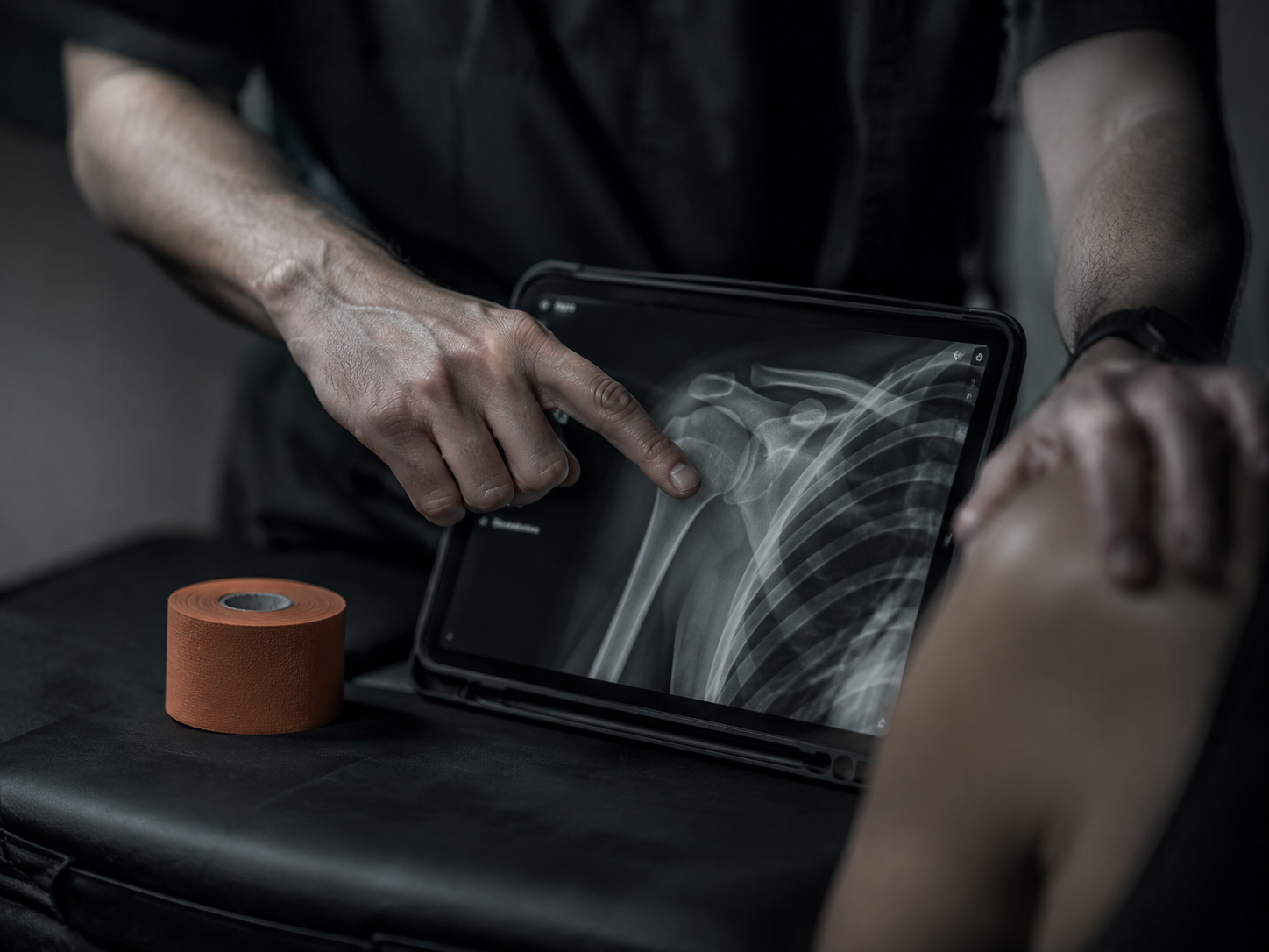 Surgeon reviewing a shoulder X-ray on a tablet